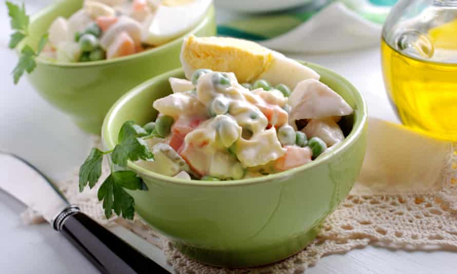 Russian salad in the bowlRussian salad with boiled eggs inside green bowl