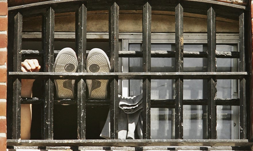 A prisoner with his feet up out of the window of a cell at Norwich Prison on August 25, 2005
