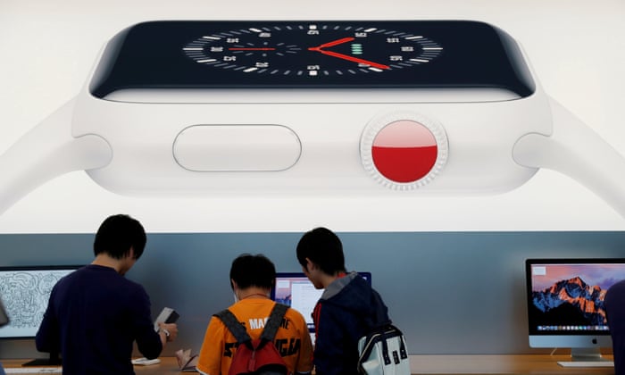 Customers are seen under a picture of Apple Watch Series 3 in Tokyo. You don’t have to go to Japan to get it at a decent price today.