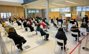 People sit in the waiting area of the Corona vaccination center at the Robert-Bosch hospital in Stuttgart, southern Germany, on 12 February, 2021.