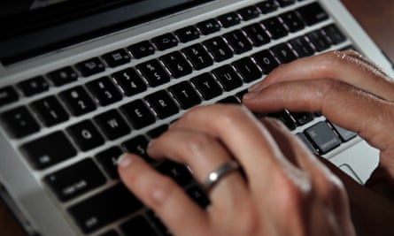 Closeup of a pair of hands typing on a laptop keyboard