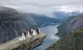 Bridal couples pose on Trolltunga rock formation in Ullensvang Municipality, Vestland county, Norway.