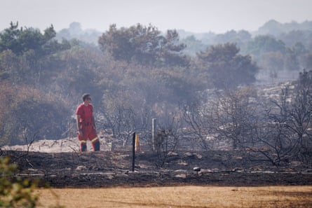 A firefighter watches smoke rising from Dunwich Heath.