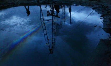 Oil derrick reflected in puddle
