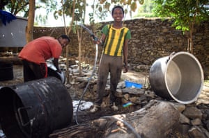 Local boys clean large cooking pots ahead of the festival