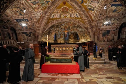 Friars pray before the remains of Francis of Assisi inside the Basilica of Saint Francis of Assisi