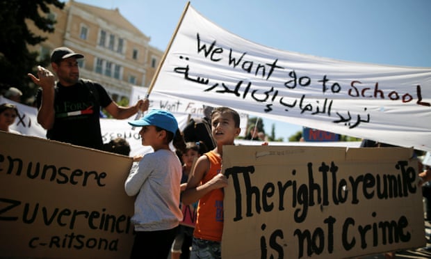 Syrian refugee children hold banners during a protest in Athens against delays in reunifying families.