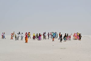 People walk across a barren-looking landscape