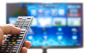 someone watching TV holding a remote control