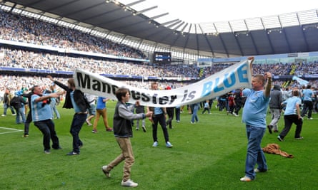 Manchester City fans invade the pitch after the final whistle to celebrate the title.