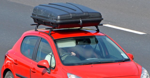 A car fitted with a large roof box on the M25