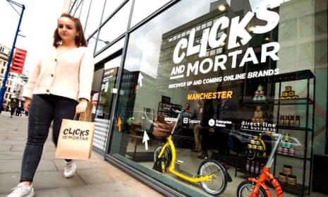 A woman carries a Clicks and Mortar bag at the launch of the first shop, in Manchester