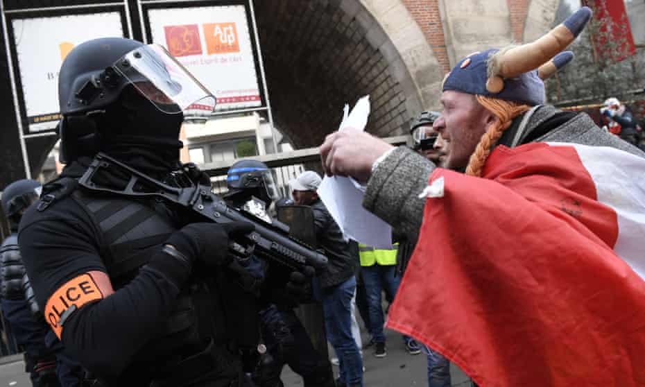 A pensions reform protester dressed as the comic book character Obelix talks to a French policeman in Paris on Saturday 11 January.