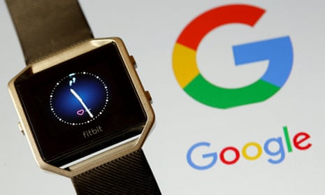 A Fitbit smartwatch beside a Google logo