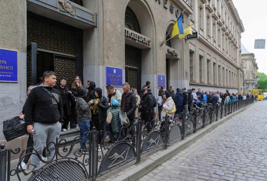 People stand in line waiting for their turn to buy postage stamps, outside a Post Office in the western Ukrainian city of Lviv on the occasion of the official release of the second of a series of Ukrainian postage stamps titled ‘Russian warship - Done!’.