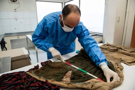 Stefano Di Lucca of Chile’s legal medical service measures an item of recovered clothing