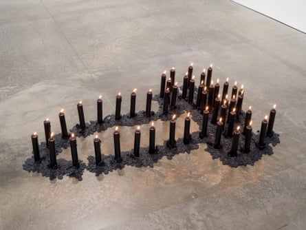An art installation of lit candles in the shape of a penis