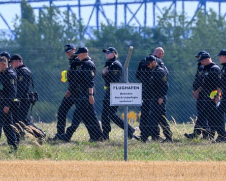Police officers behind a fence at the airport