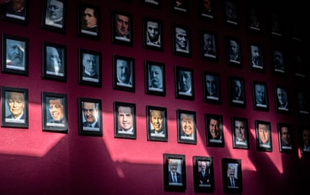 Portraits of US presidents hanging on a dark red wall.