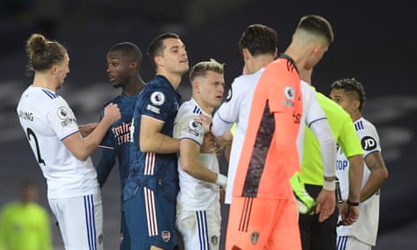 Granit Xhaka of Arsenal holds back Ezgian Alioski of Leeds United as Pepe is shown a red card.