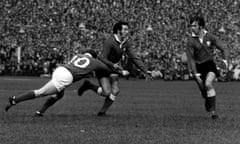 Gareth Edwards passes the ball to Wales teammate Barry John (right) during a match against Ireland in 1971.