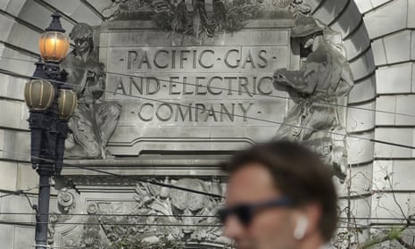 A man walks past the Pacific Gas &amp; Electric building in San Francisco.