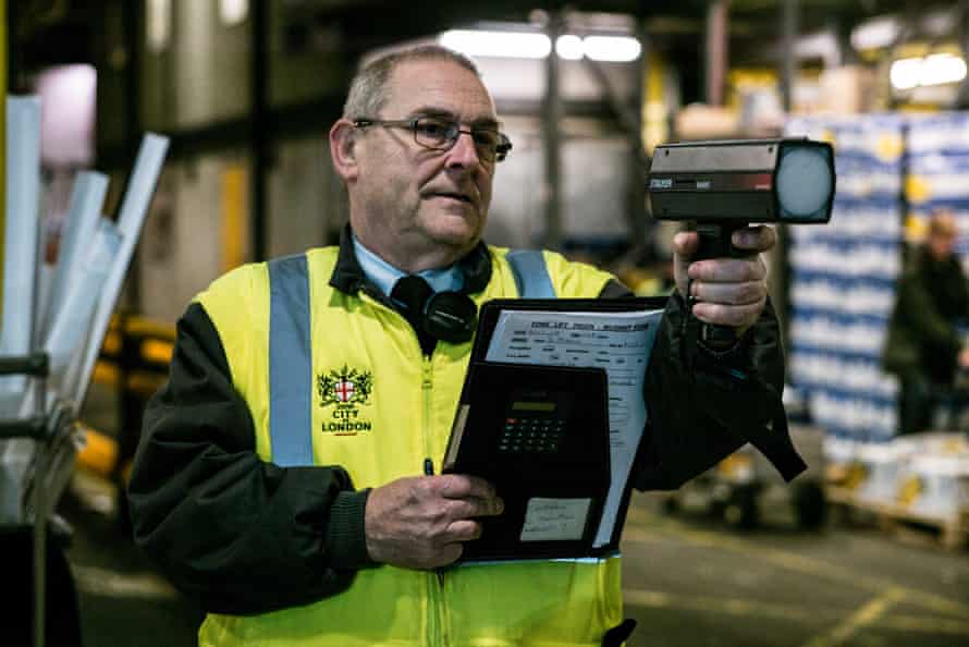 Clive Thompson, market constable at New Spitalfields Market, checks the speed of a forklift truck.