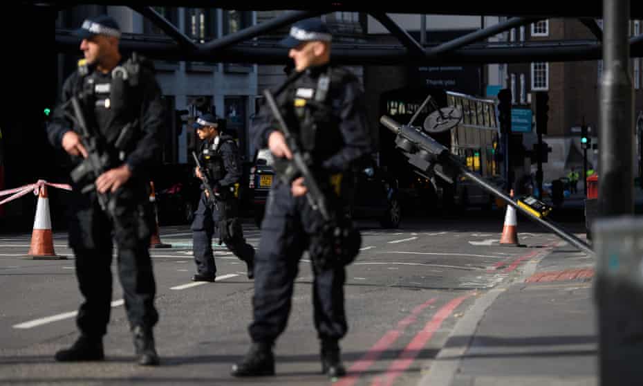 Armed police officers stand near the location of Saturday night’s attack.