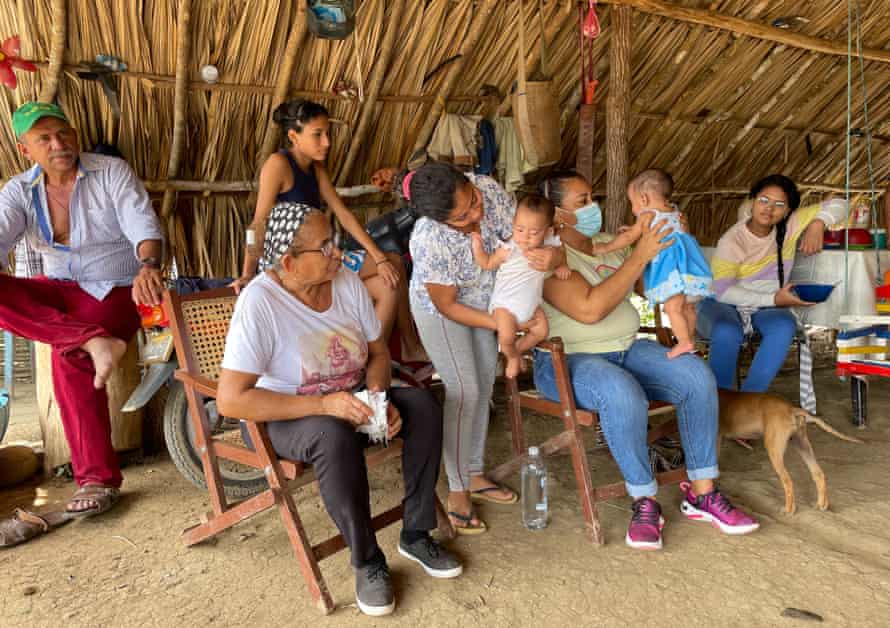 Yirley Velasco, seated with baby, visits families in a rural area of Montes de Maria
