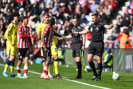 Referee Rob Jones rules out a Tottenham Hotspur penalty after reviewing VAR.