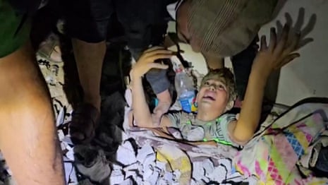 Gaza: moment children are pulled from rubble after home hit by Israeli airstrike – video