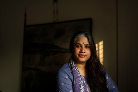 Portrait of a smiling woman in a blue blouse with a bindi on her forehead