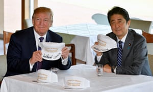 Donald Trump and Shinzo Abe pose with their customised white baseball caps,