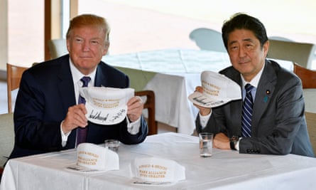 Donald Trump and Shinzo Abe pose with their customised white baseball caps,