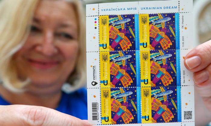 A woman at the central post office of Odesa holds up a sheet of new stamps commemorating Ukrainian resistance to the Russian invasion