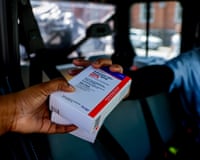 a person handing a person a small box of medication
