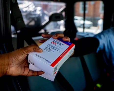a person handing a person a small box of medication