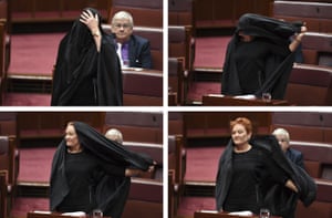 One Nation leader Pauline Hanson takes off a burqa she wore wore to question time in the Senate chamber.