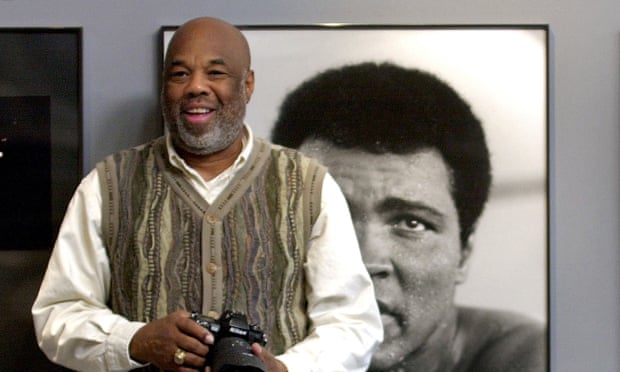 Howard Bingham stands next to photos of Muhammad Ali, part of an exhibit of his works in 2002 at the Smithsonian in Washington