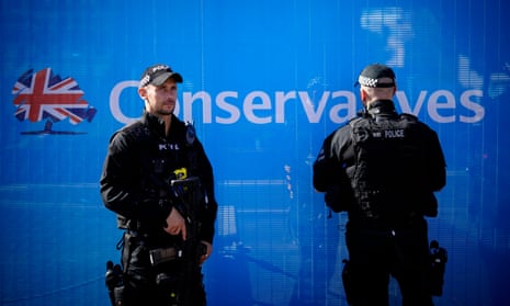 Armed police officers patrol and keep watch as politicians and delegates begin to arrive for the annual Conservative party conference.