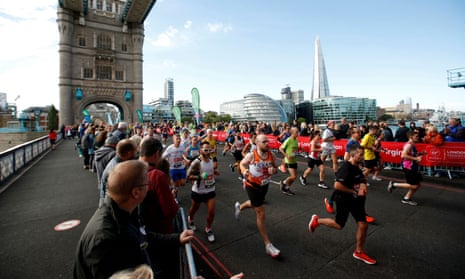 Spectators watch runners during the London Marathon as they run over Tower Bridge.