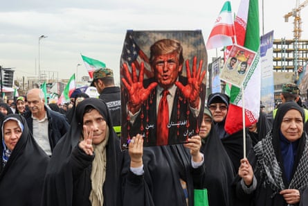 Women march with a sign depicting Trump with bloodied hands in Tehran