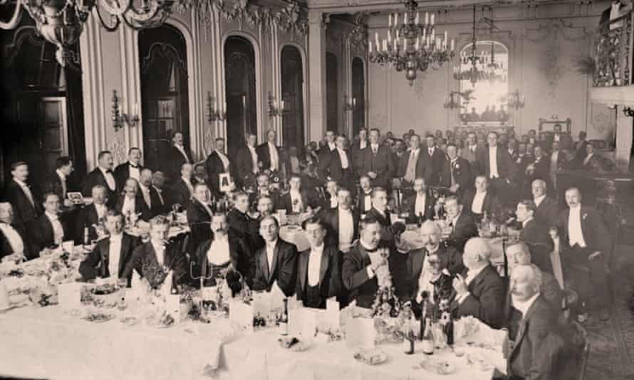 Dinner suited Edwardian men in grand ballroom