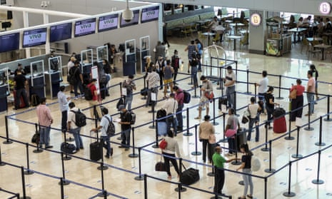 Tourists wait to check in at the airport in Cancún, Mexico.