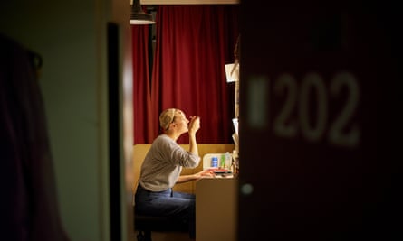 Katherine Kingsley puts on makeup in front of a mirror