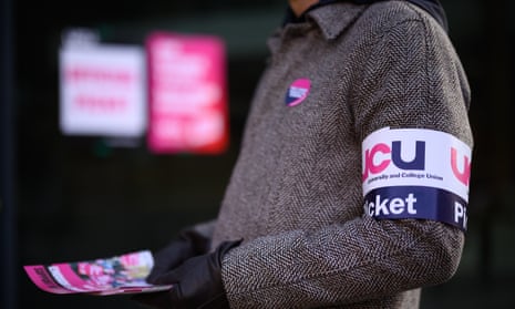 Person wearing a UCU picket line armband and holding a leaflet