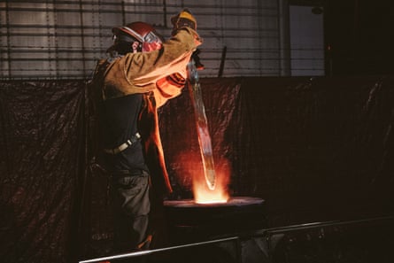 A foundry worker places the sword from Charlottesville’s bronze monument of Robert E. Lee into a heated furnace to melt it.