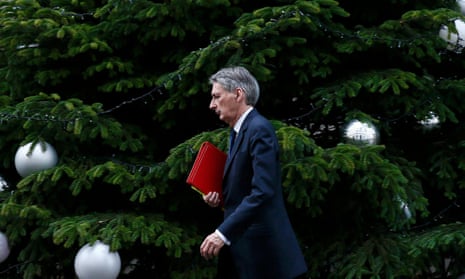 Philip Hammond walks past the Christmas tree as he leaves No 10 Downing Street
