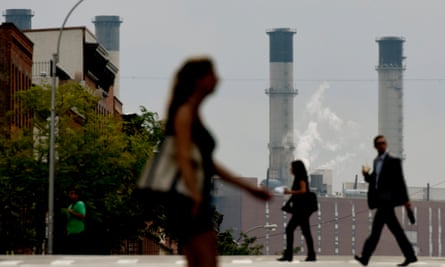 people walk with power plant towers in the background