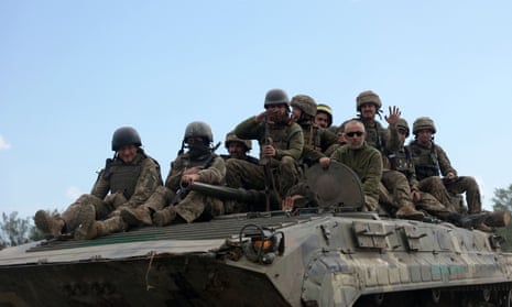Ukrainian soldiers ride on an armoured personnel carrier on a road of the eastern Luhansk region yesterday.